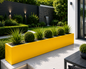 Yellow  garden planter with green plants in a modern garden setting